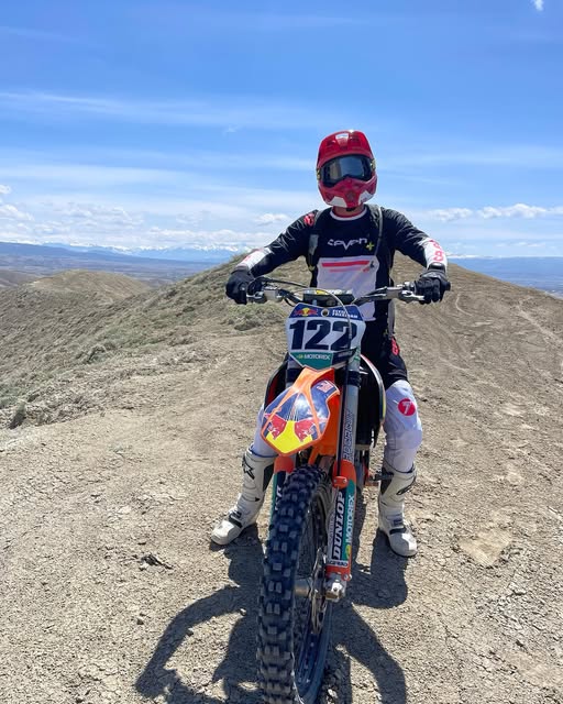 Dakota Freeman on his dirt bike on a mountain ridge with a view of the valley