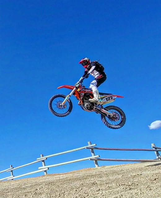 Dakota Freeman smiling on a dirt bike on a winding mountain road